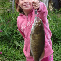A proud girl shows off her prize catch of a fish caught from Miller Lake